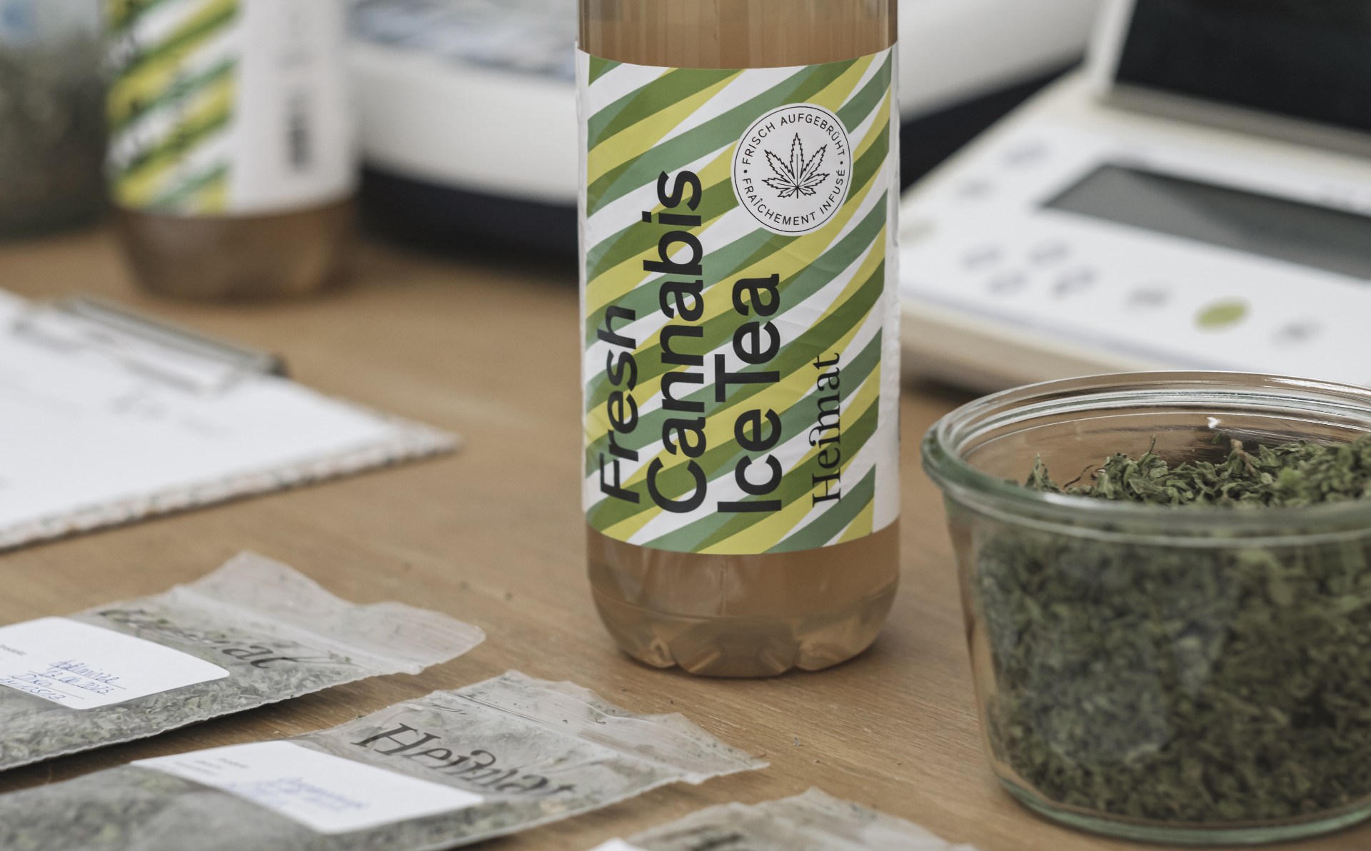 Heimat Fresh Cannabis Ice Tea — Prototyp-Flasche im Entwicklungs-Setting mit Teebeuteln und Kräutern